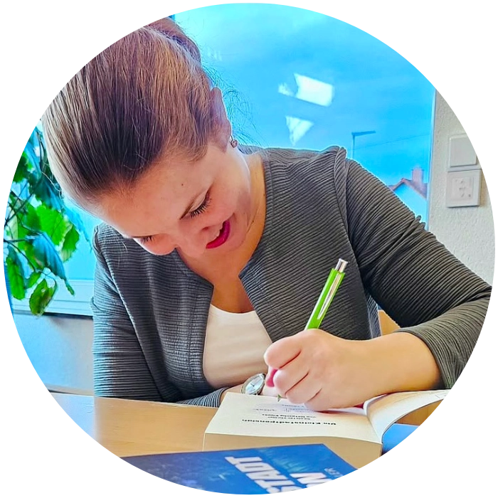 Natascha Kippes signiert ein Buch.